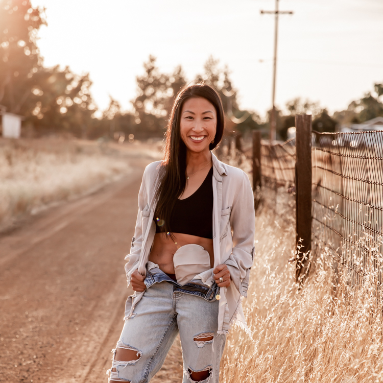 Diana smiling outdoors near a fence