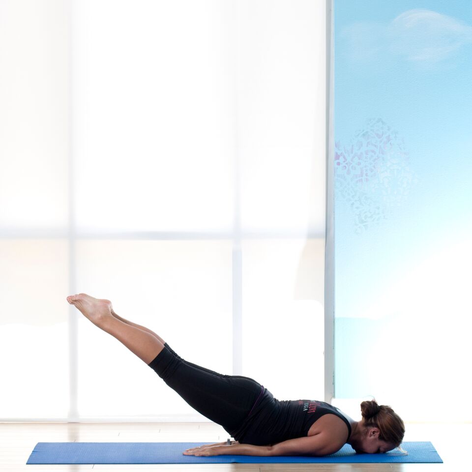 a hatha yoga instructor posing with her head to waist on the floor and her legs pointed up at a 45 degree angle