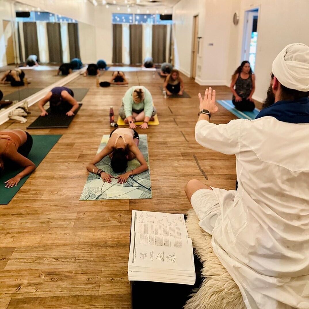 a classroom is receiving instruction from their teacher with his hand out in a corrective manner