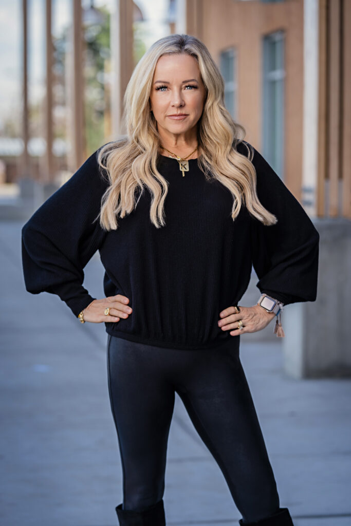 Kathleen Spain posed with her arms at her hips near a business building