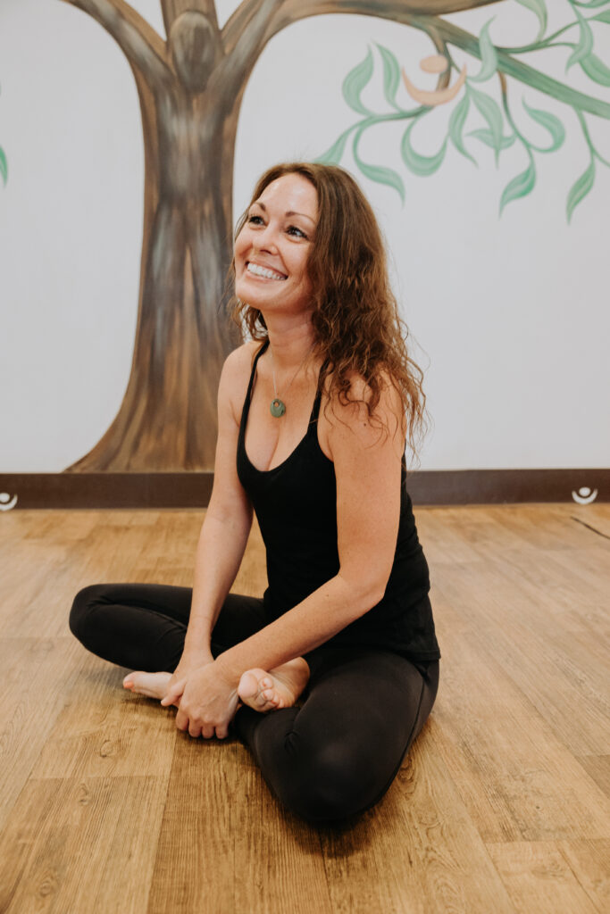 Taryn Cole smiling on the floor in a seated position in the classroom