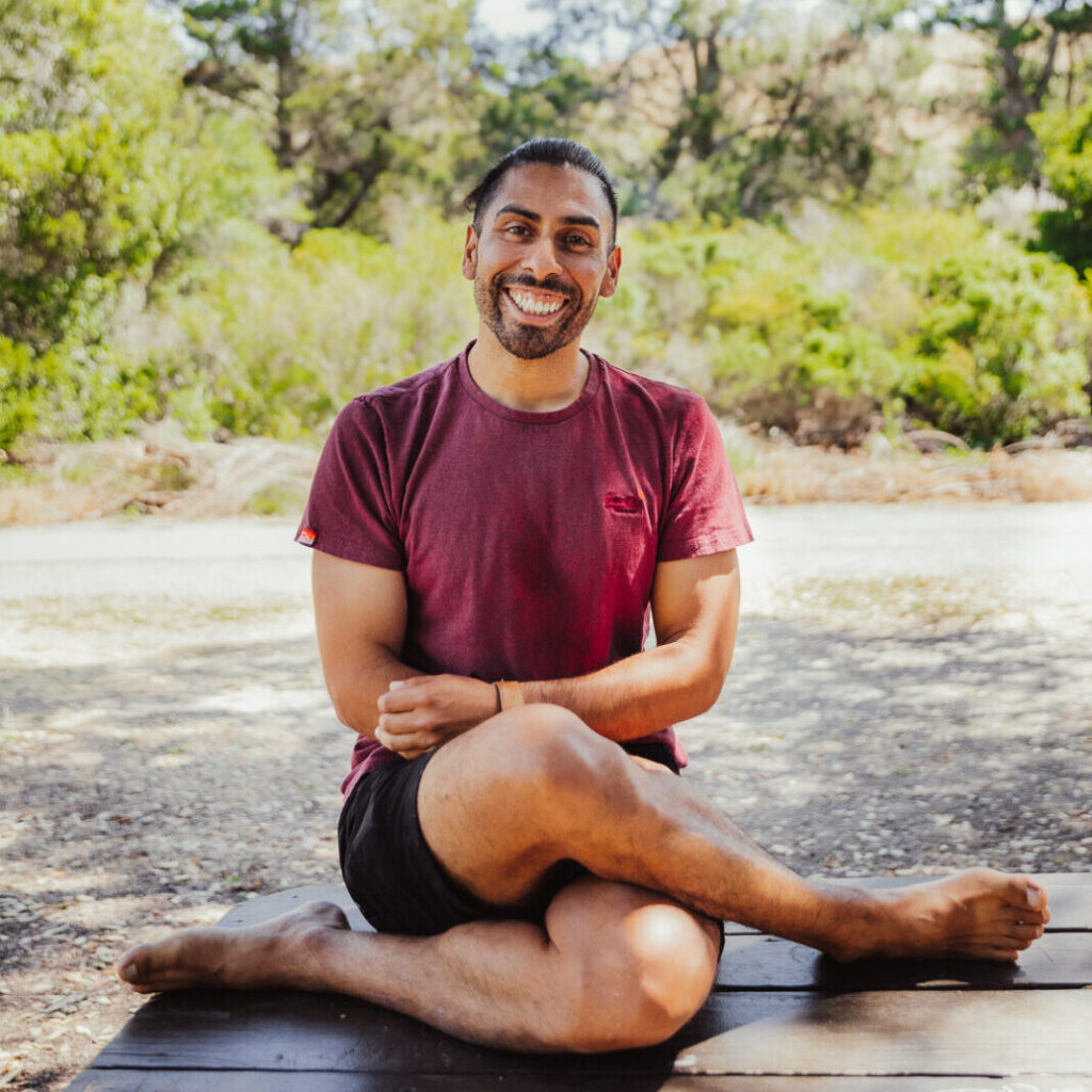 carlos diaz smiling while seated outdoors in a trail environment