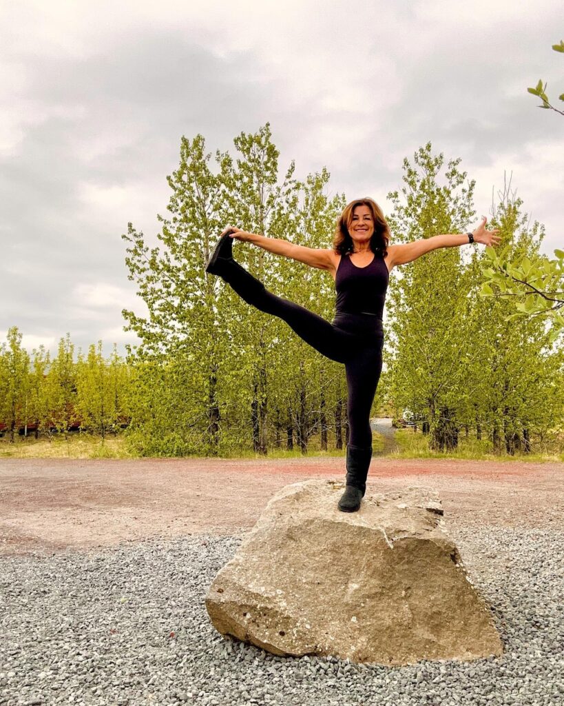 Lori Wilson doing a pose on a rock outdoors